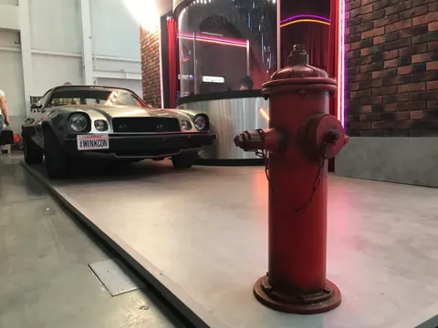 Camaro и красный пожарный гидрант у фасада кинотеатра