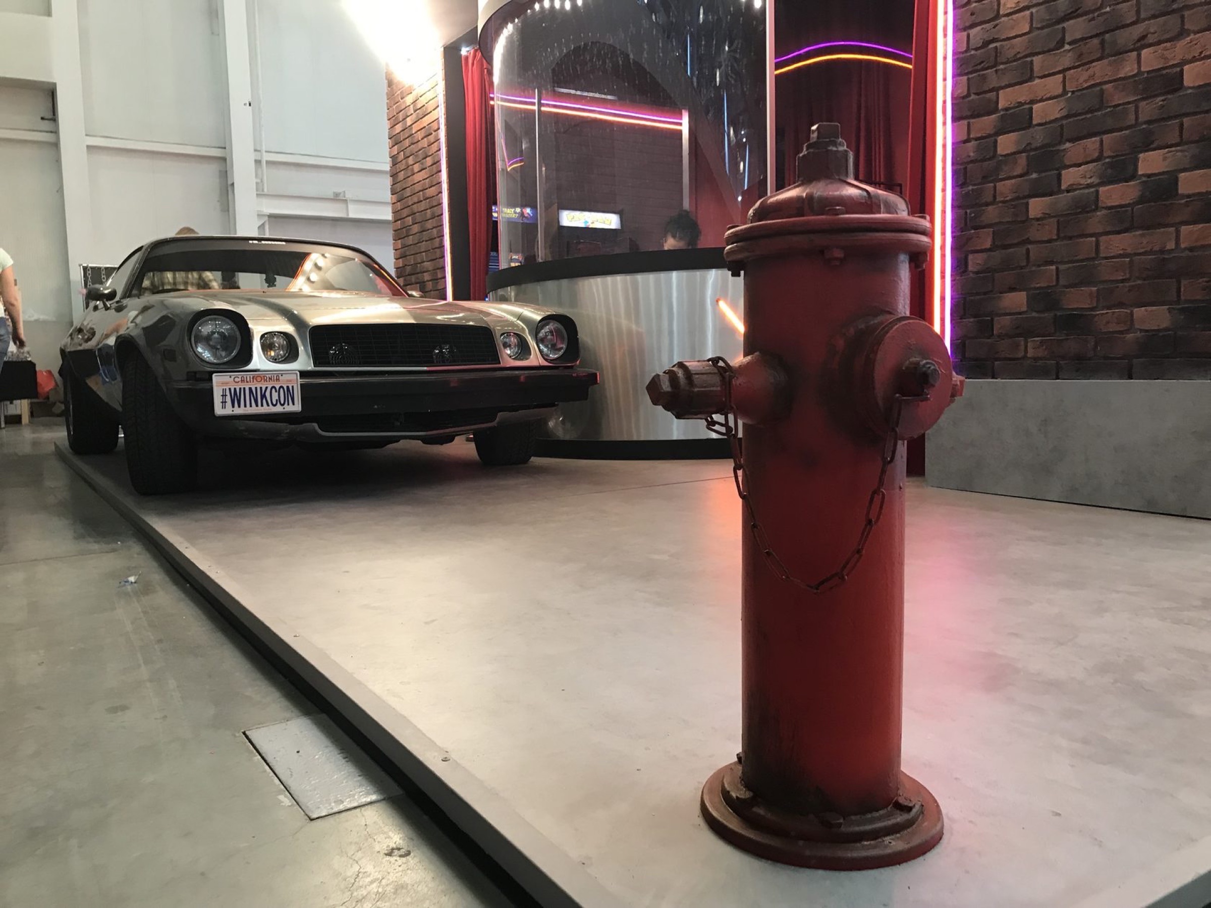 Camaro и красный пожарный гидрант у фасада кинотеатра