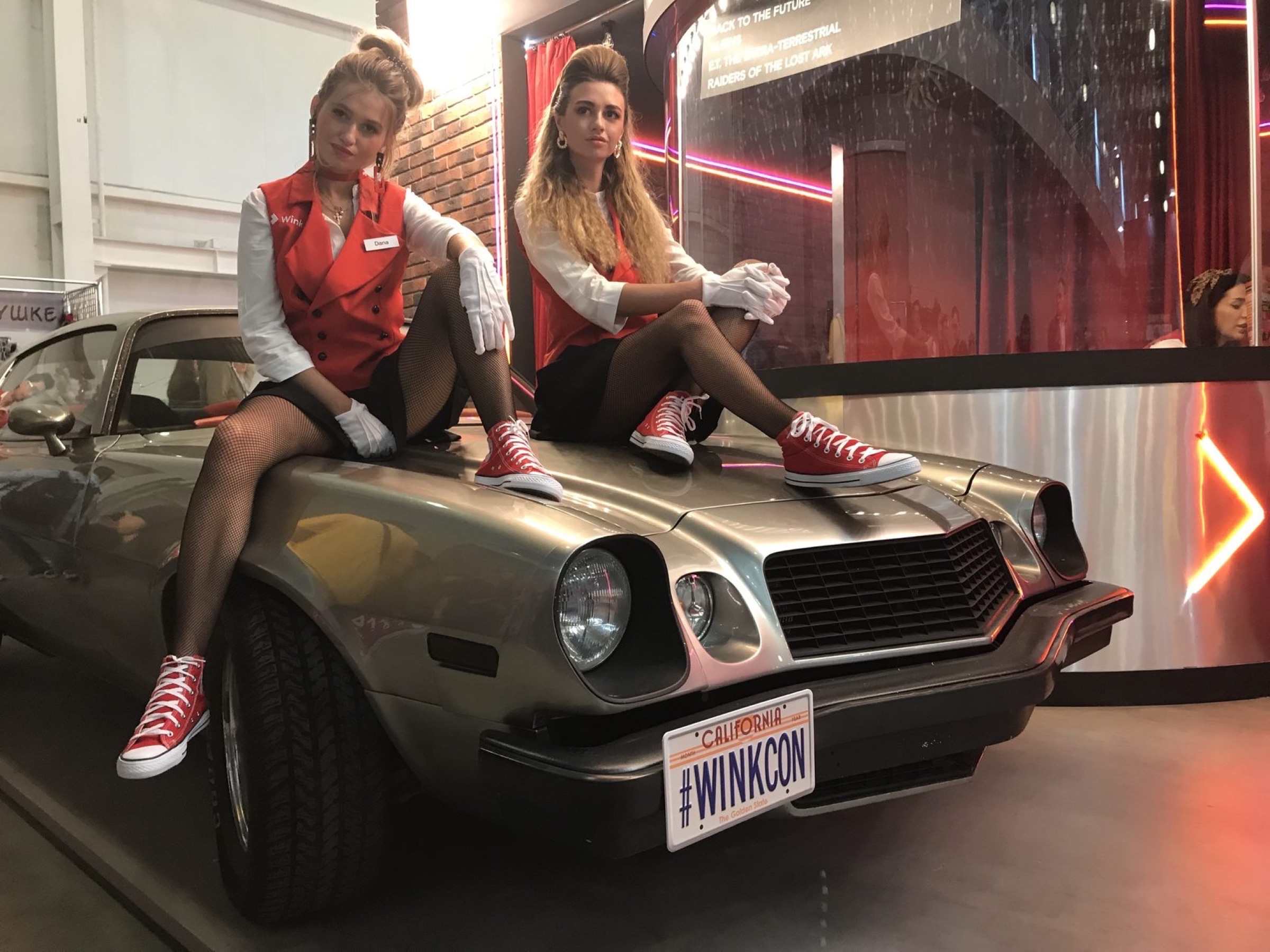 Двое из команды павильона на капоте Camaro